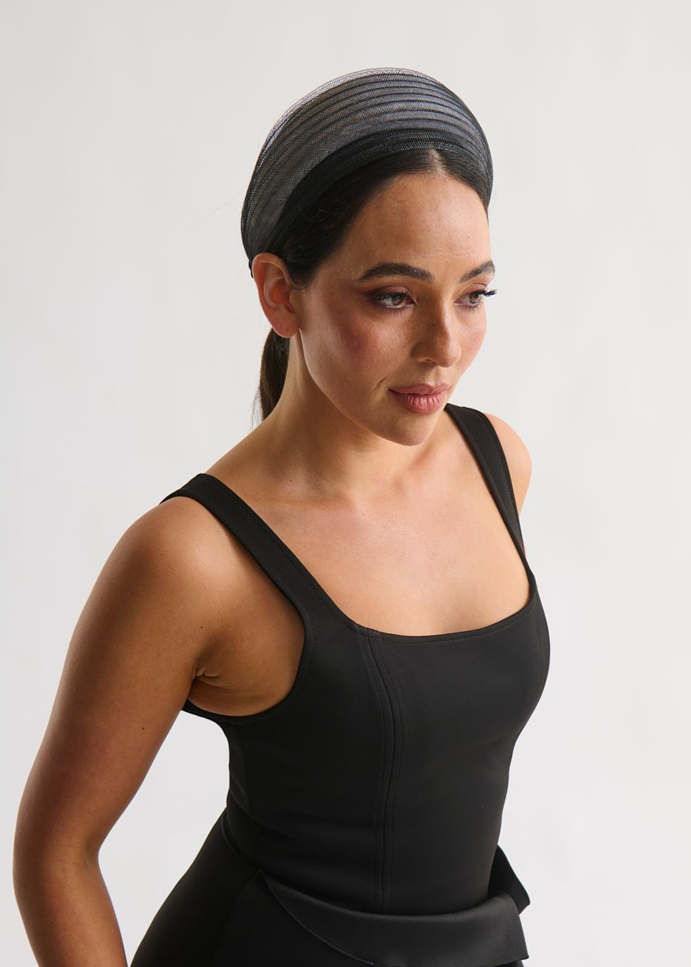 Woman wearing a black dress and headband on a white background