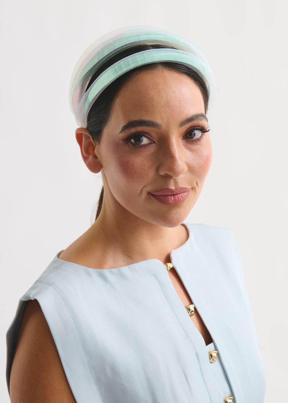 Woman wearing a mint headband against a white background