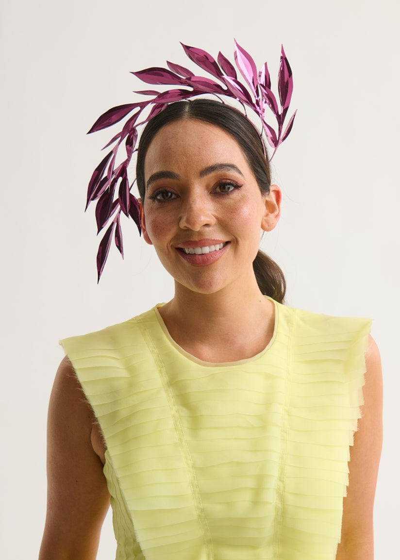 Woman wearing a leaf headpiece and yellow dress with a white background