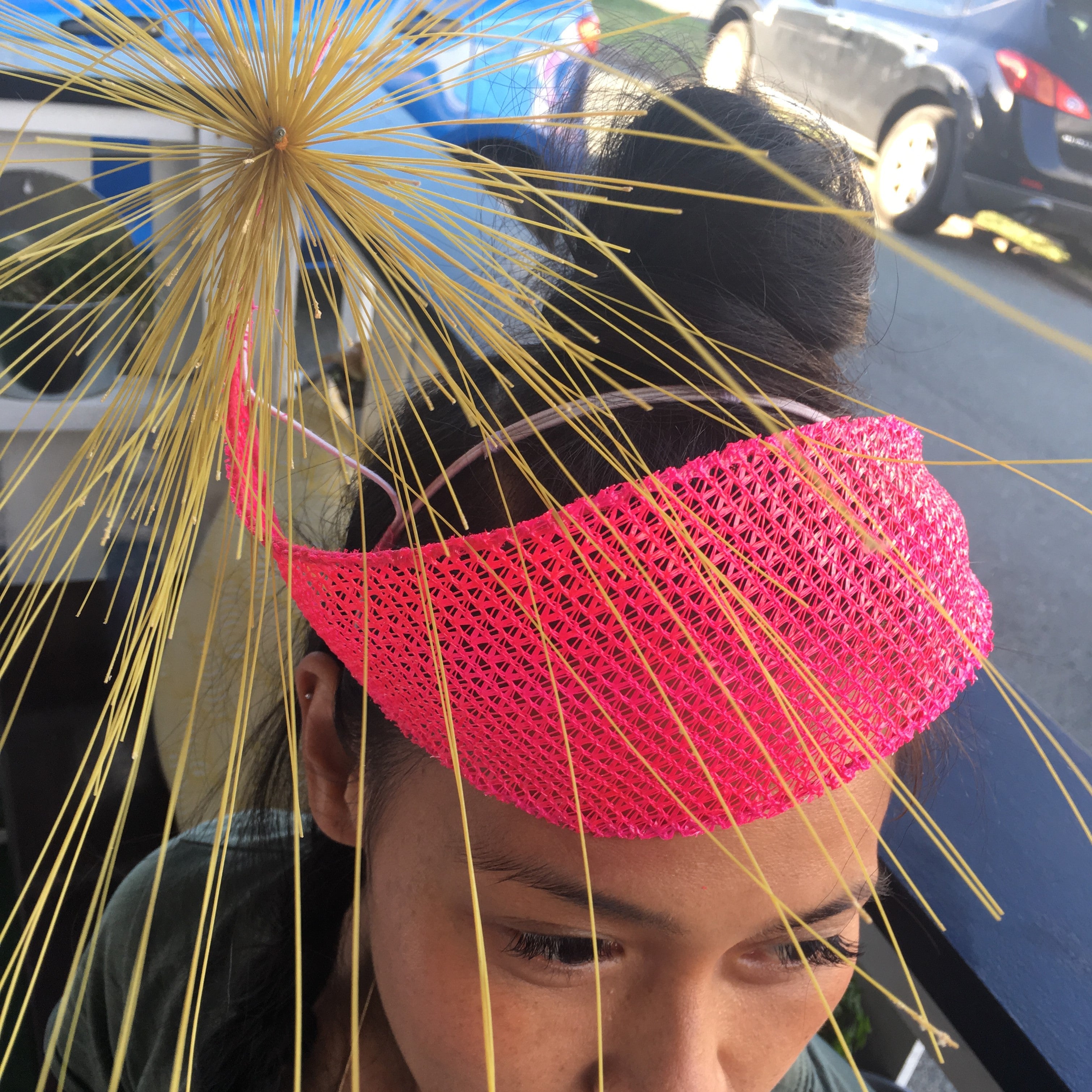 Close up of a pink hat with golden spikes on a woman with brown hair
