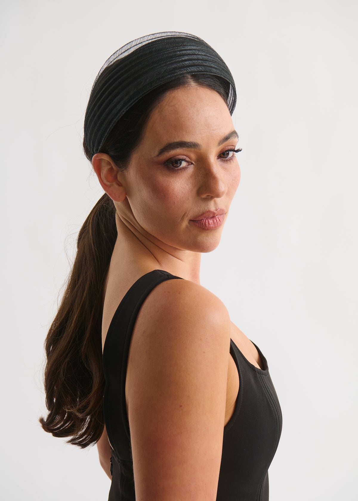 Woman wearing a black headband against a white background