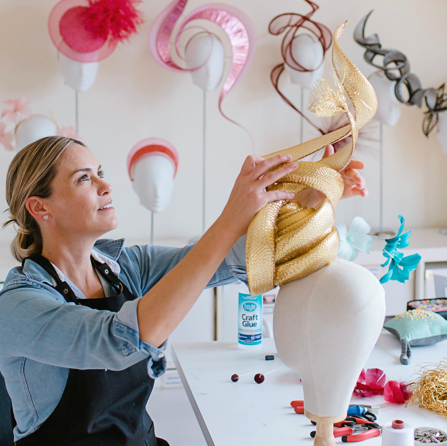 Rebecca Share in her millinery workshop working with a mannequin to create bespoke headwear creations