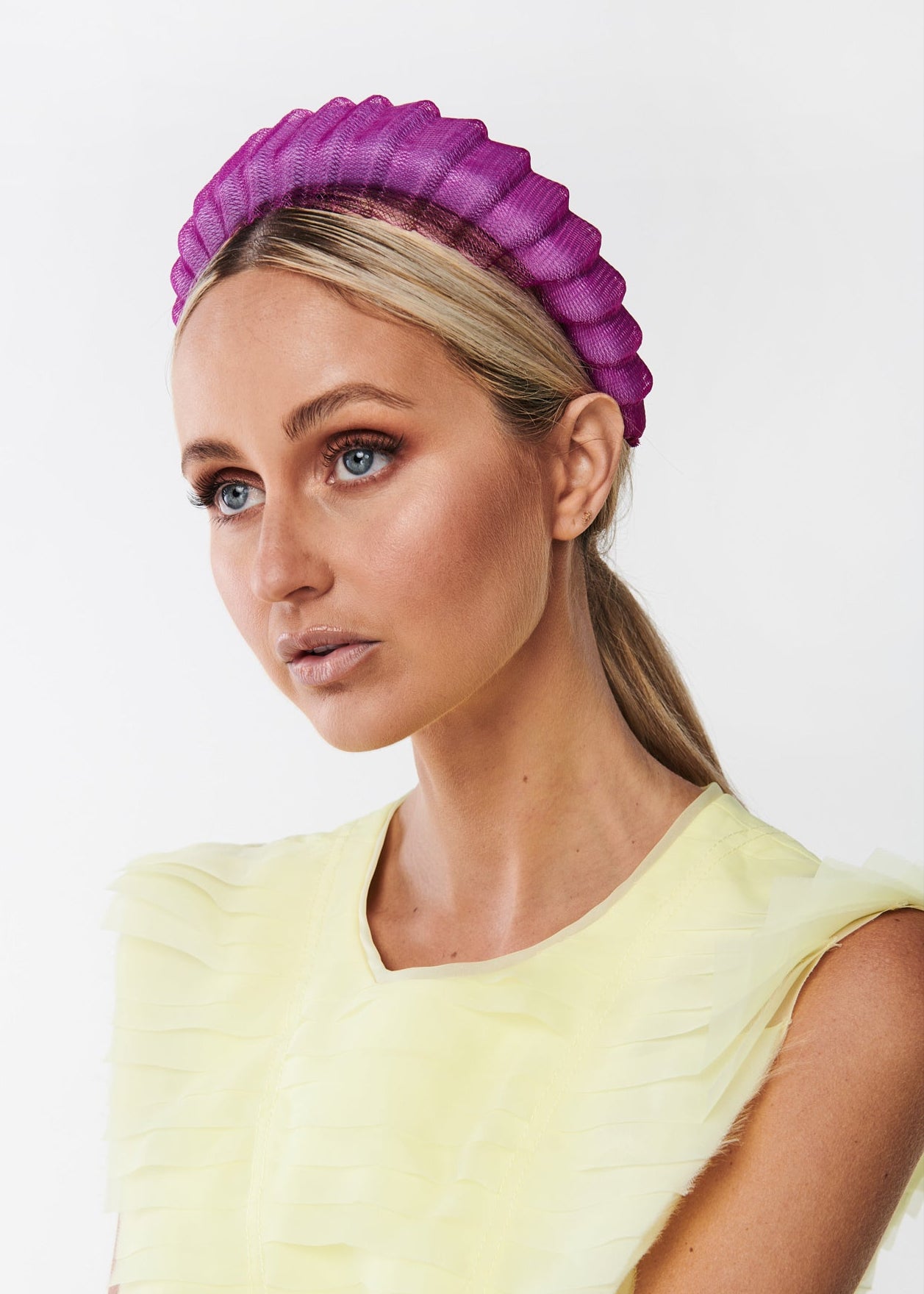Woman wearing a purple headband against a white background
