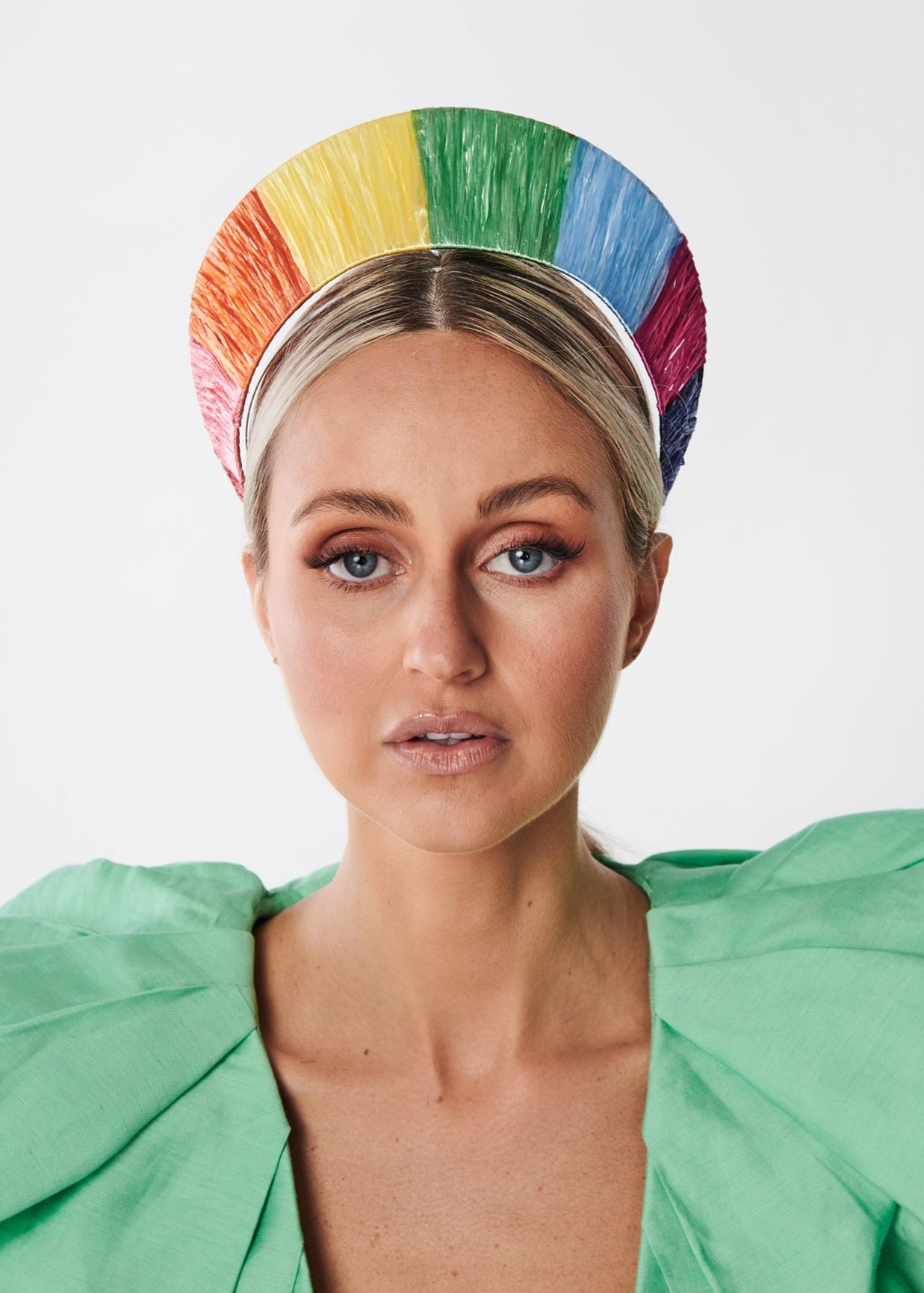 Person wearing a colorful rainbow headband with a white background