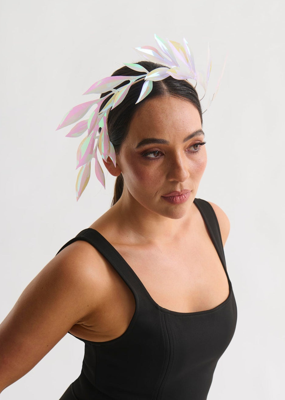 Woman wearing a leaf headpiece and black dress with a white background