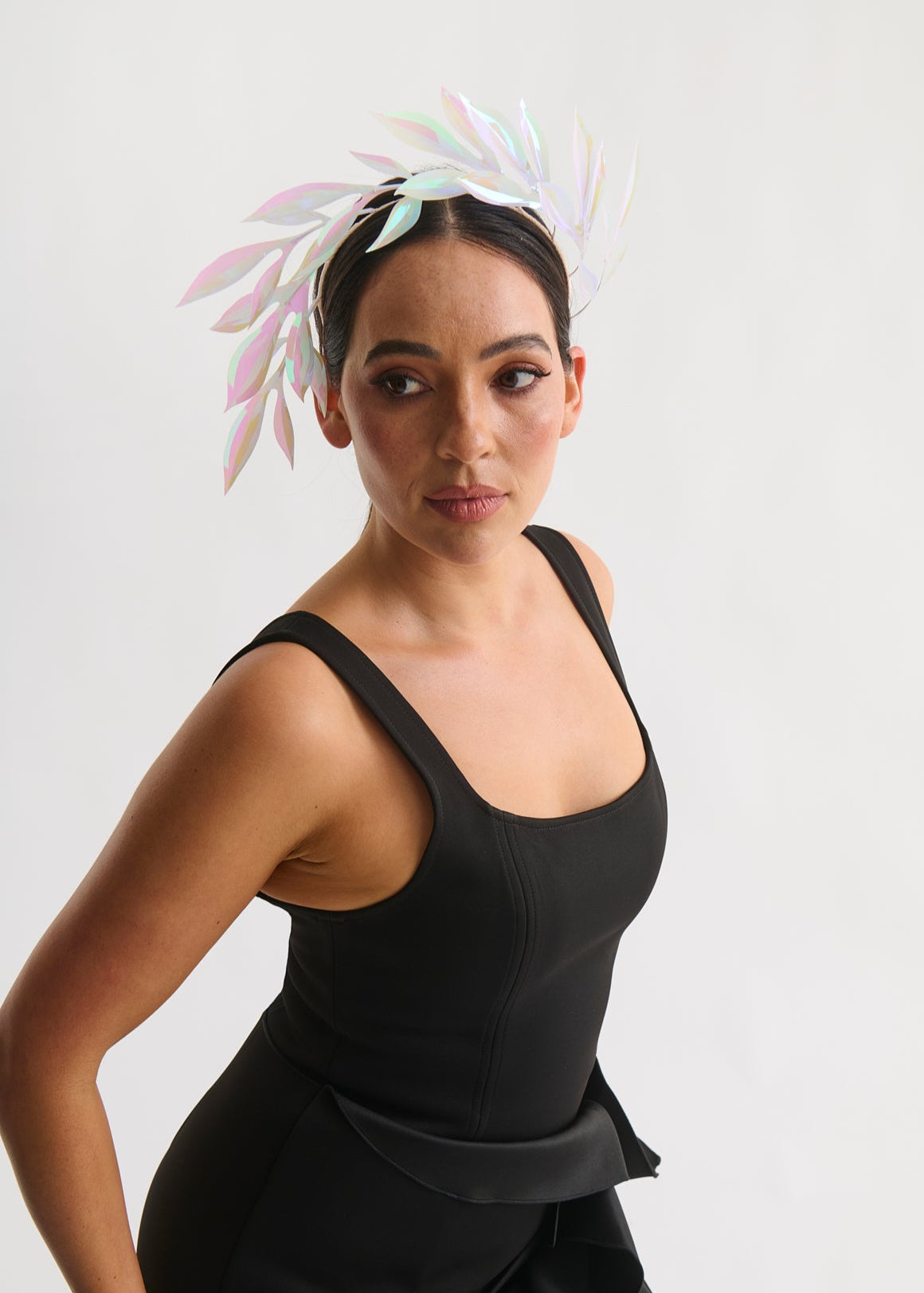 Woman wearing a leaf headpiece and black dress with a white background