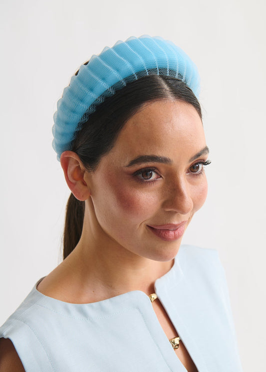 Woman wearing a light blue headband against a white background