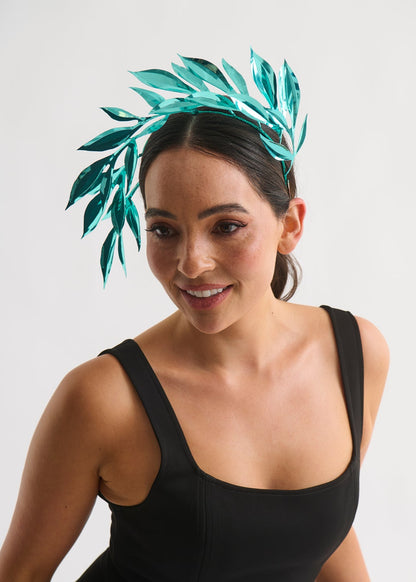 Woman wearing a leaf headpiece and black dress with a white background
