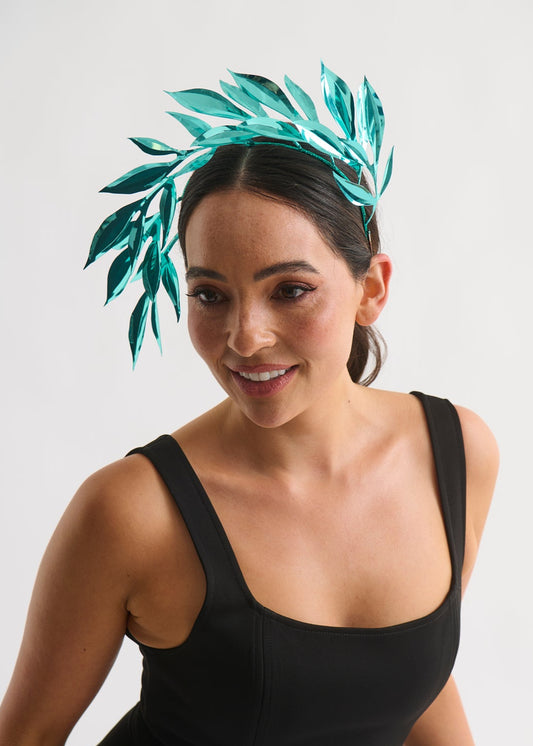Woman wearing a leaf headpiece and black dress with a white background