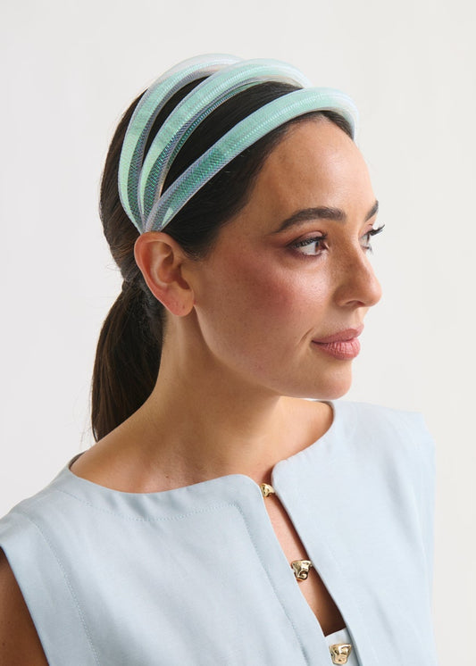 Woman wearing a light blue headband against a white background