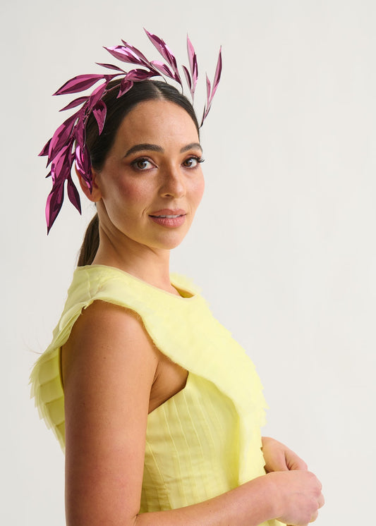 Woman wearing a leaf headpiece and yellow dress with a white background