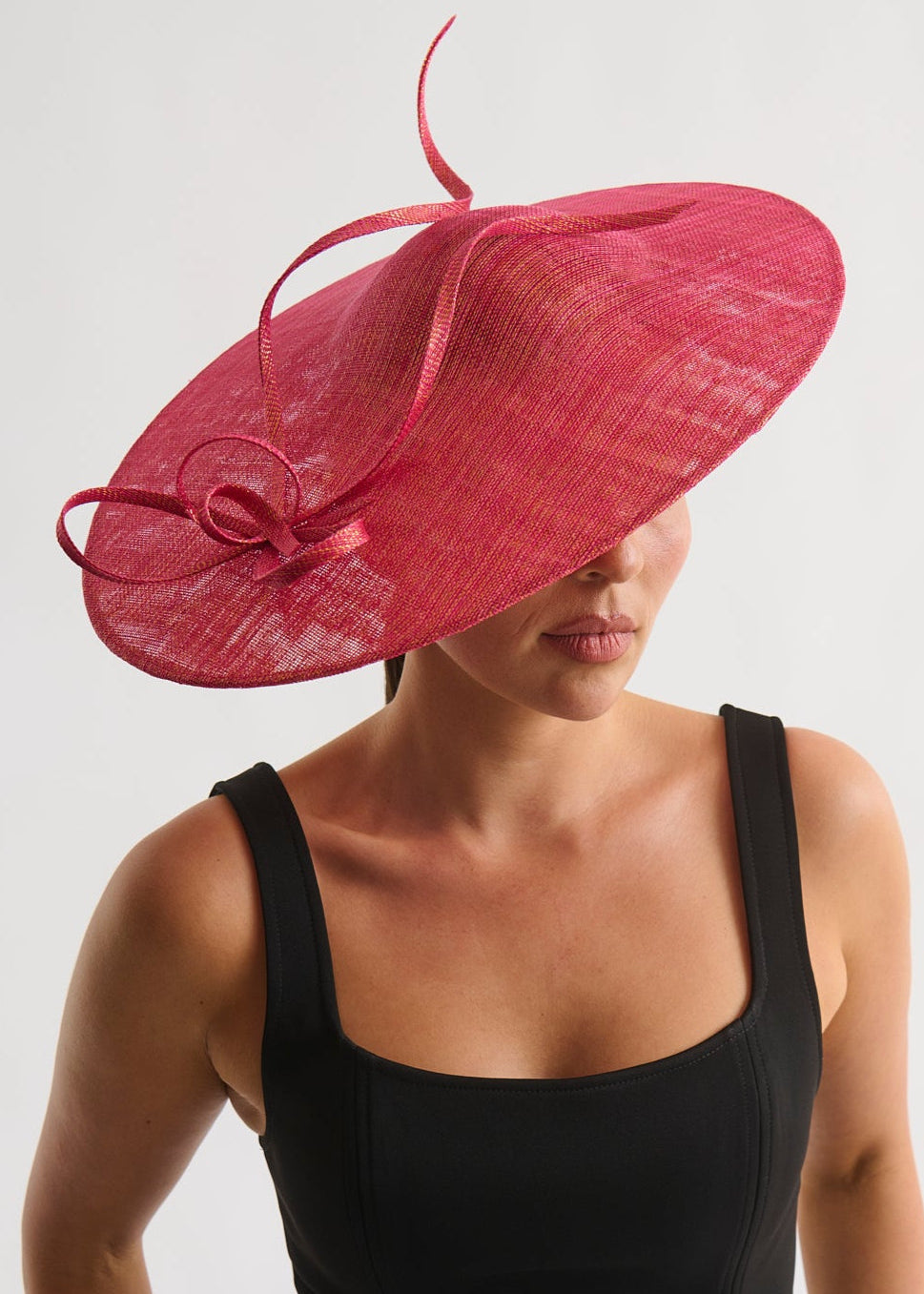 Woman wearing a black dress and a red decorative hat on a white background