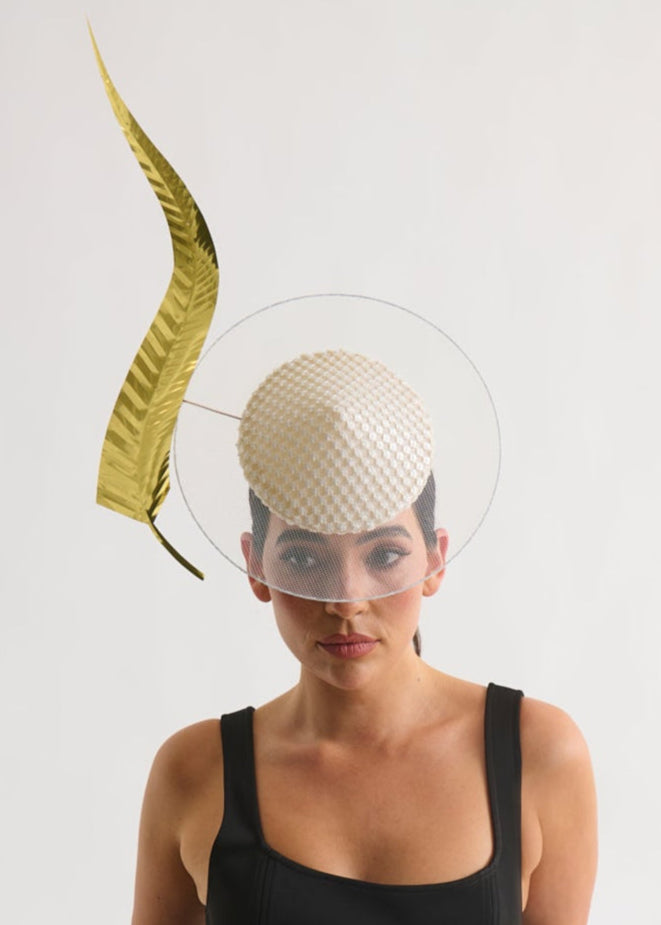 Woman wearing a black dress with a decorative hat on a white background