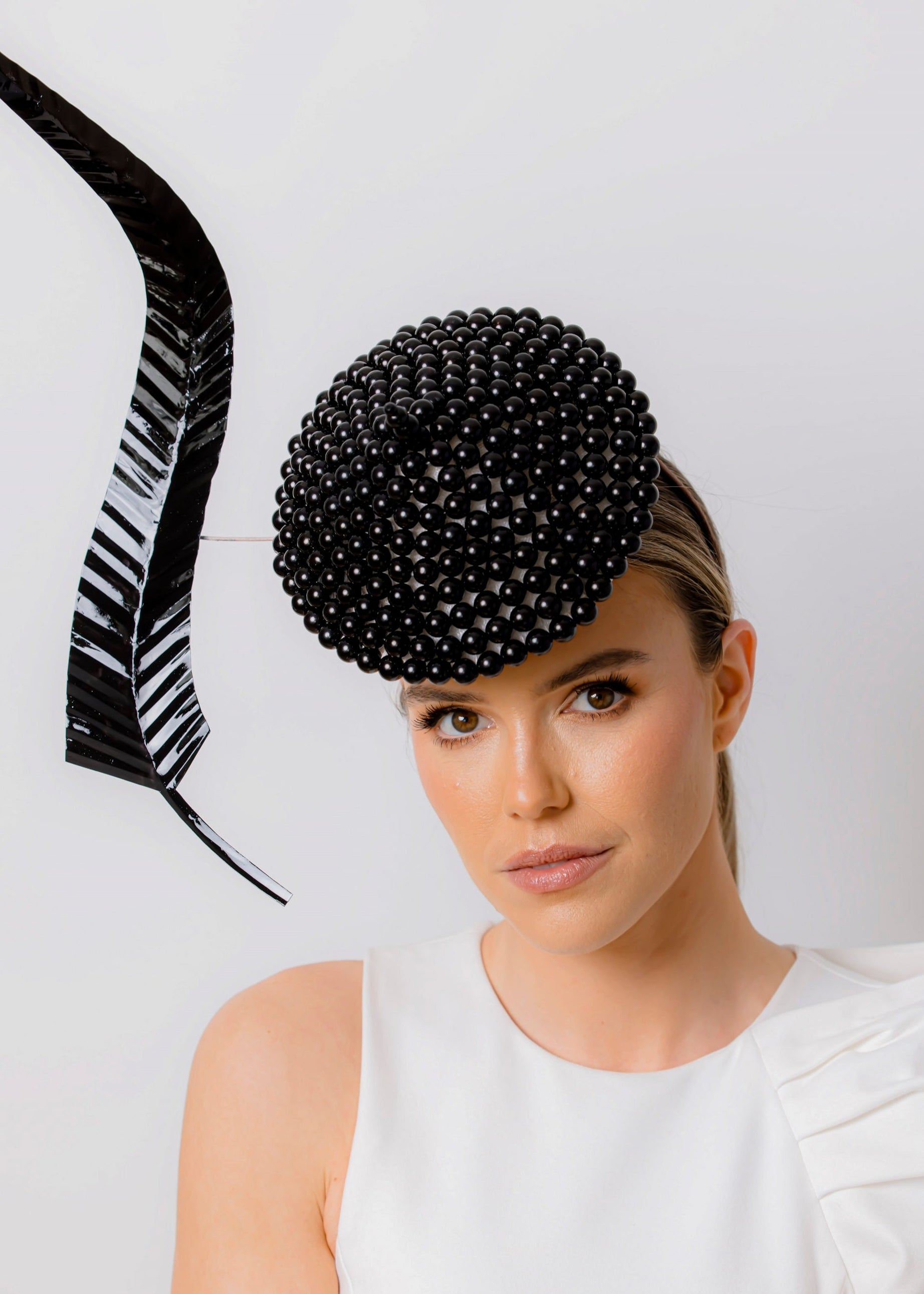 Woman wearing a black beaded hat against a white background