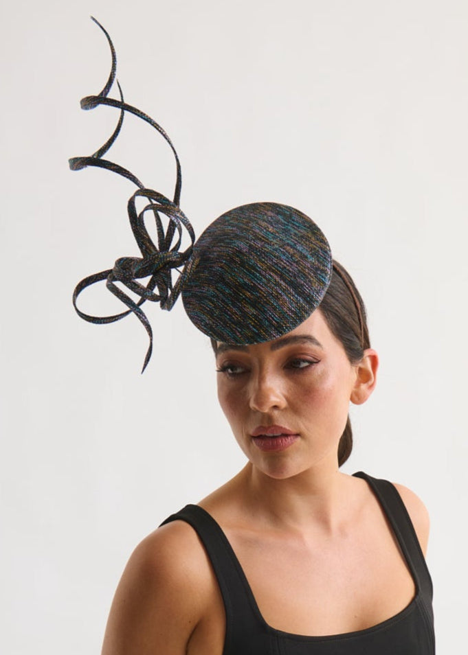 woman wearing a black hat and dress against a white background