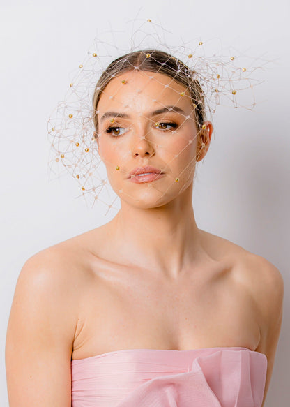 Woman wearing a strapless pink dress against a plain background