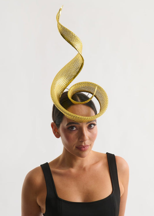 Woman wearing a black dress with a gold swirl headpiece on a white background
