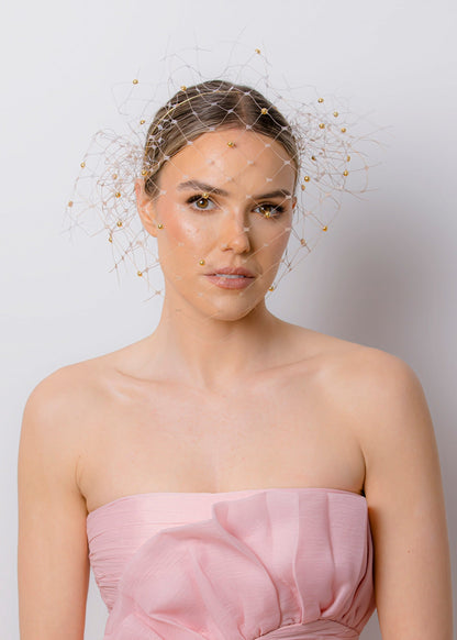 Woman wearing a strapless pink dress against a plain background