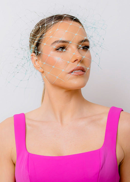 Woman wearing a bright pink dress against a plain background