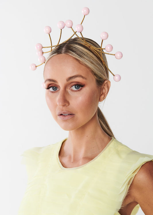 Woman wearing a yellow dress and beaded headband with a white background