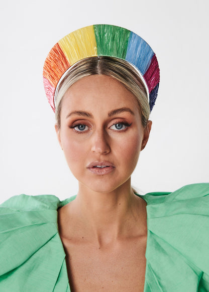 Person wearing a colorful rainbow headband with a white background