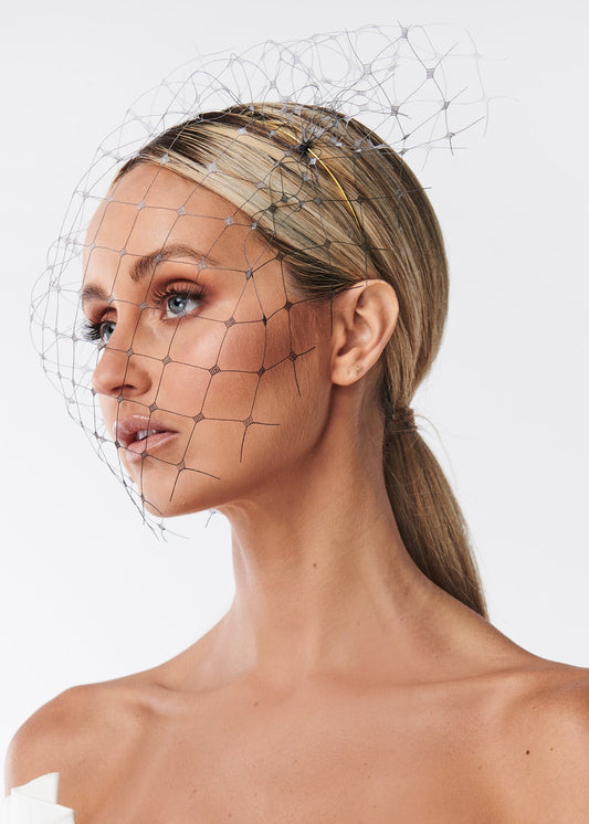 Woman with a netting face veil on a white background