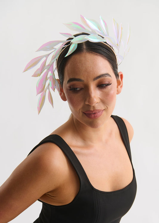 Woman wearing a leaf headpiece and black dress with a white background