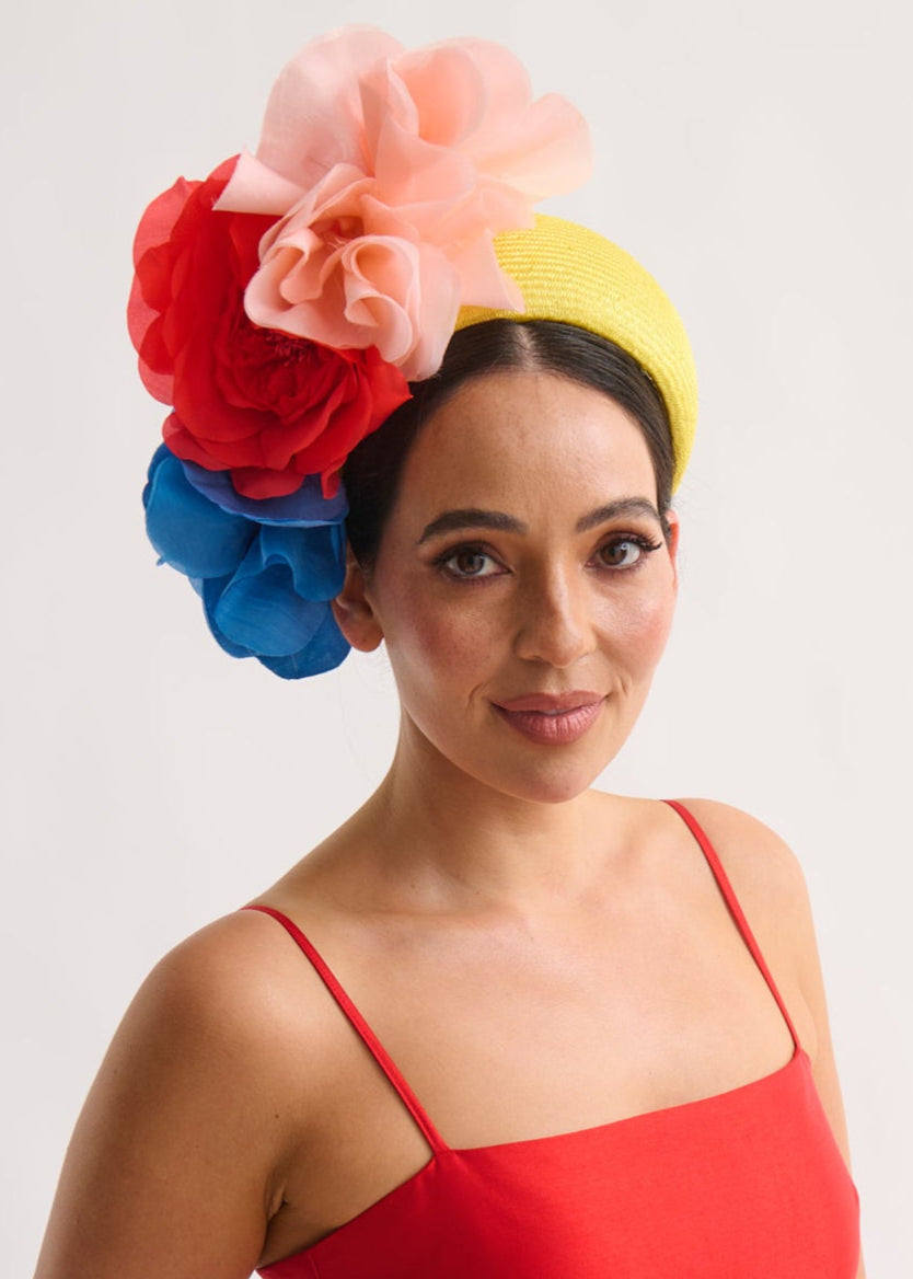 Woman wearing a colorful headband and red dress against a white background